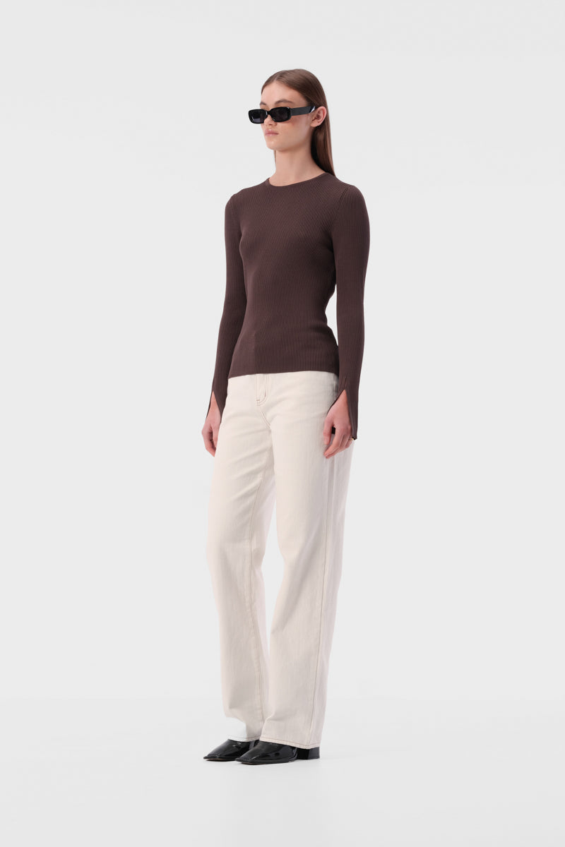 Slim fit knit top with round neckline and ribbed texture. Full length sleeve with split hem.