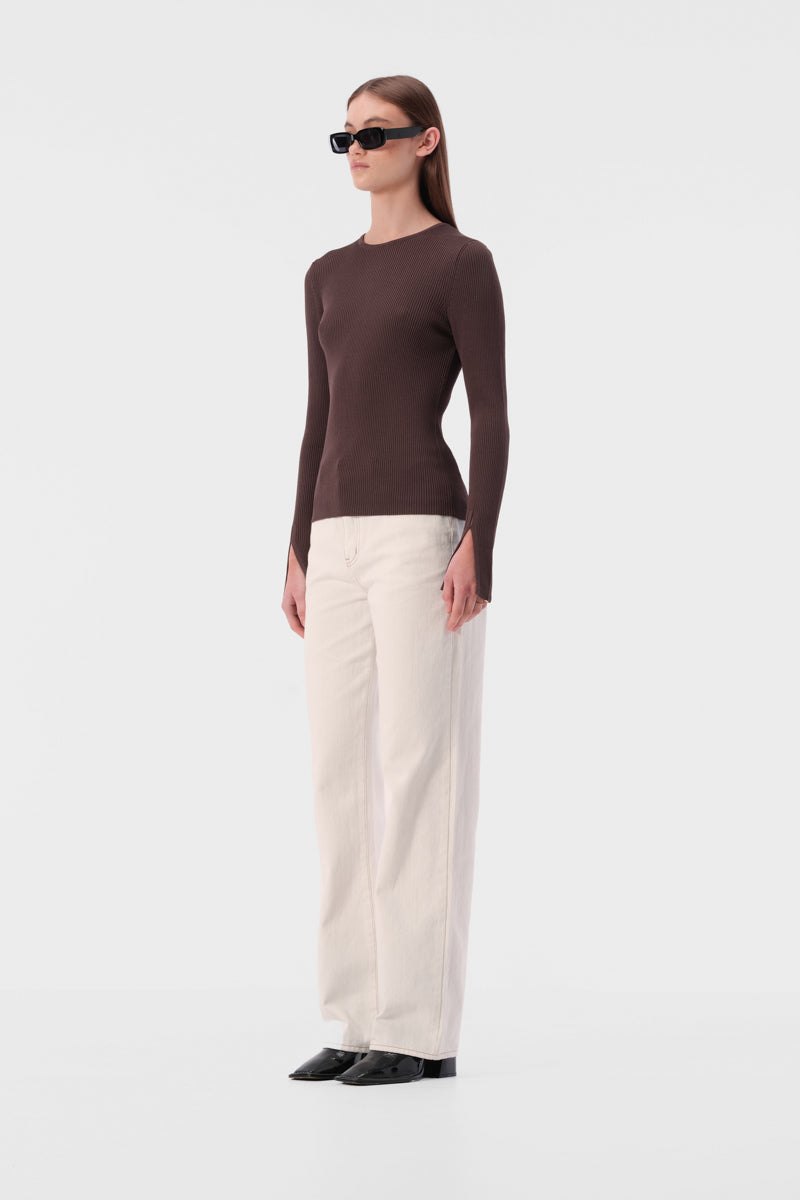 Slim fit knit top with round neckline and ribbed texture. Full length sleeve with split hem.
