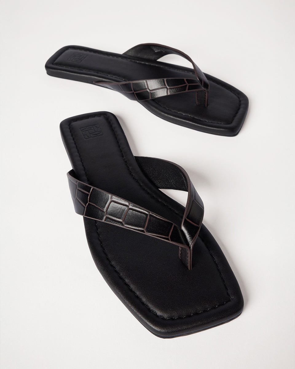 Brown sandals with a crocodile pattern on a white background