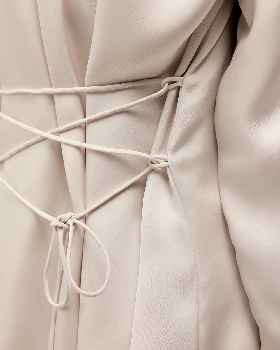 Close-up of a beige garment with lace-up detail